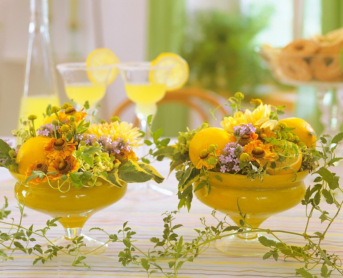 Glass bowls with Helenium, hydrangeas, Verbena, lemons