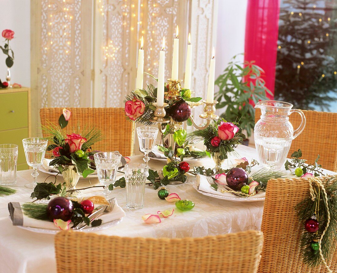 Christmas table with roses, pine, ivy and tree ornaments