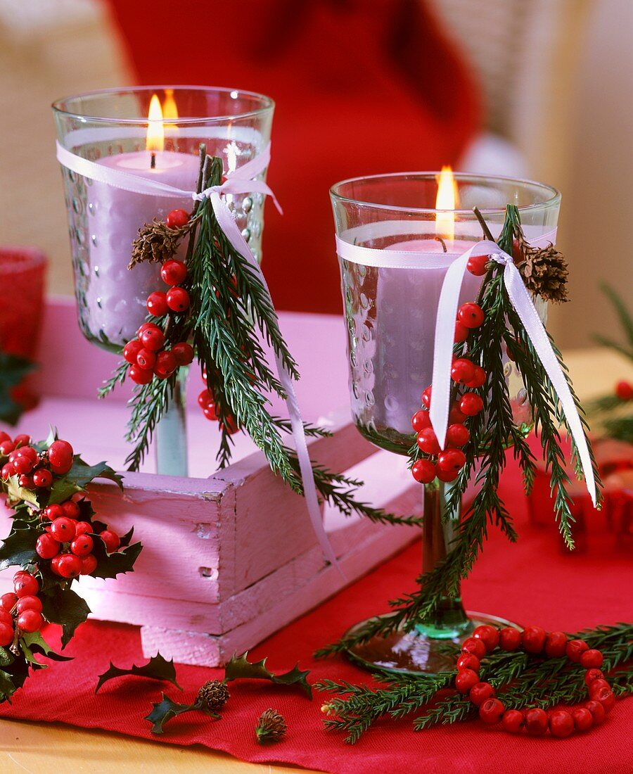 Green wine glasses with pink candles on pink tray