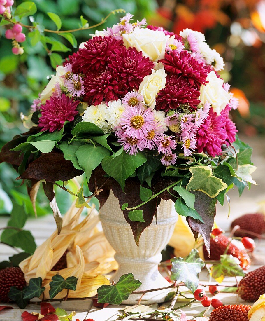 Autumn arrangement of chrysanthemums, asters, roses and ivy