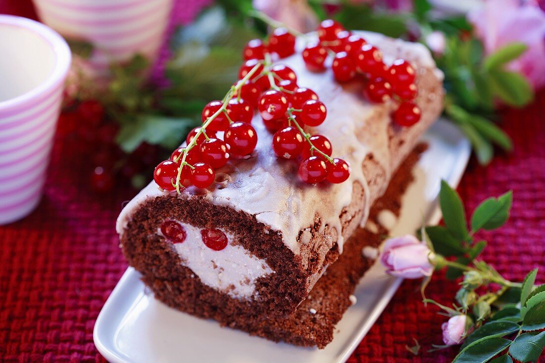 Schokoladenrolle mit roten Johannisbeeren