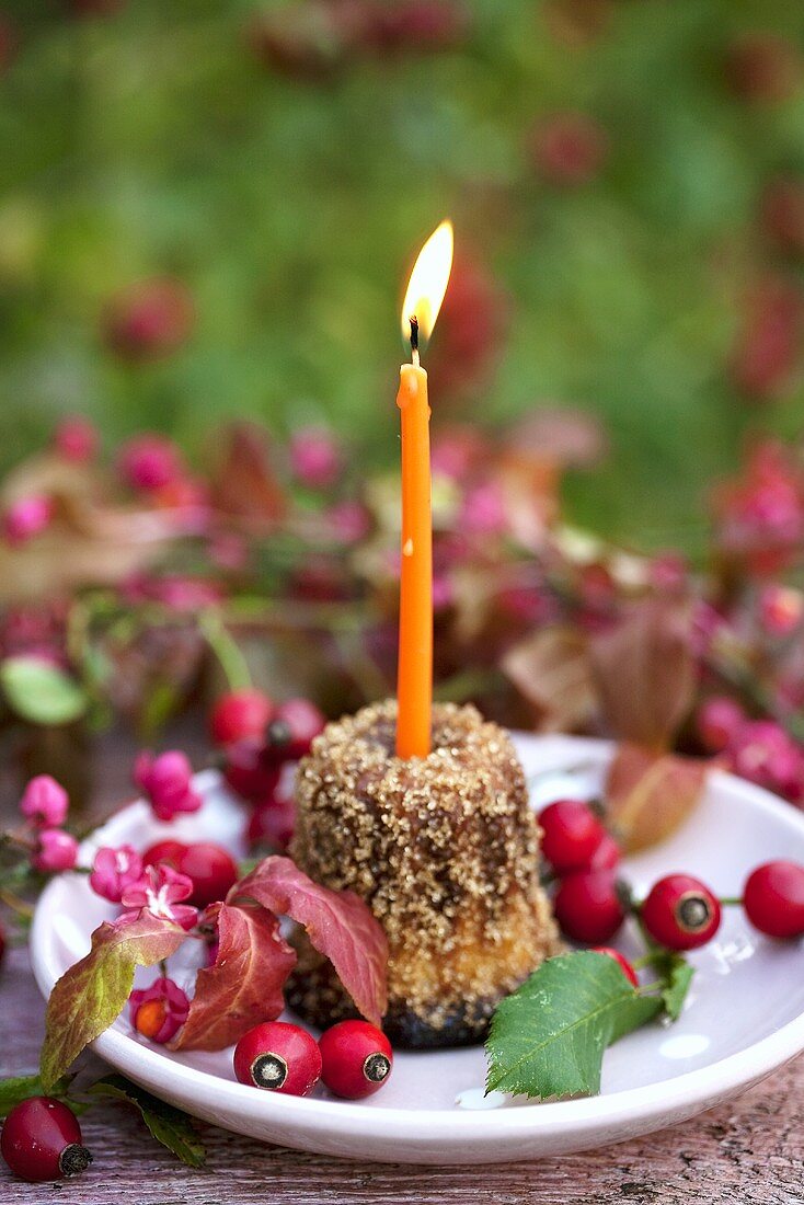 Cannele with candle and rose hips