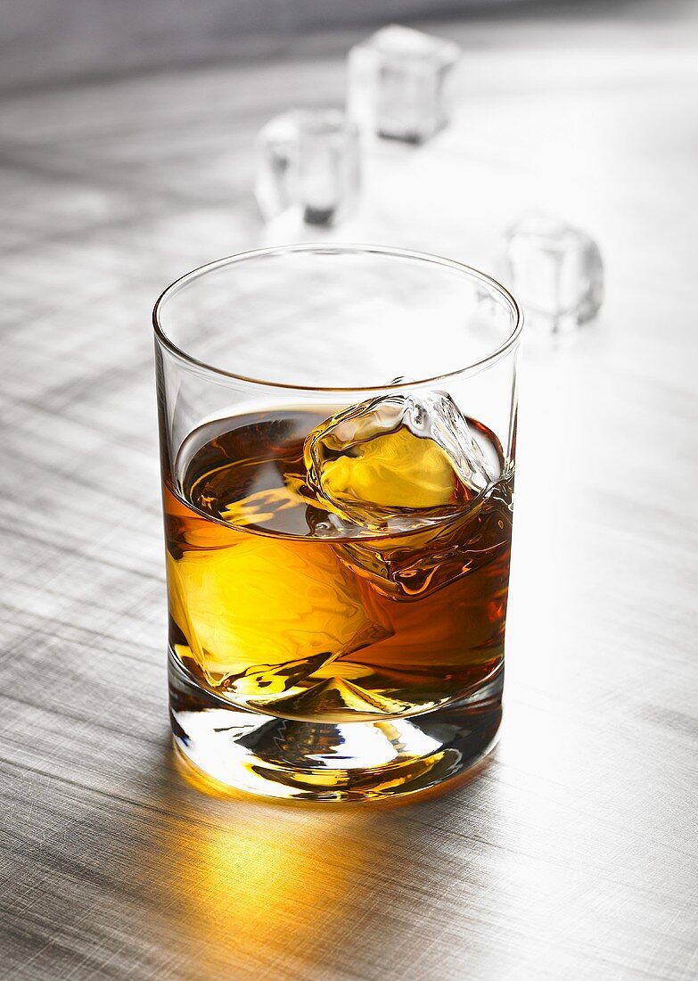 Glass of whisky with ice cubes