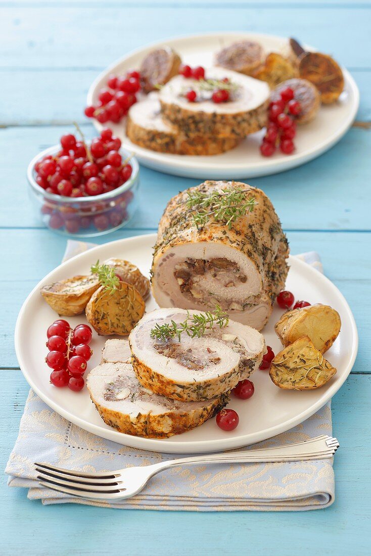 Stuffed pork roulade with roast potatoes and redcurrants