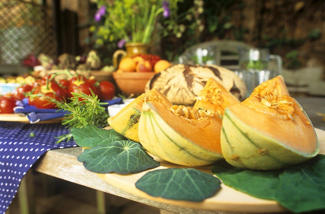 Sommerlicher Tisch mit Cantaloupemelone und Landbrot