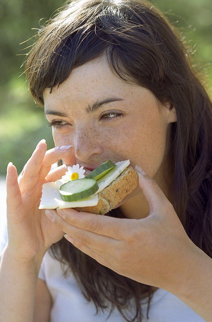 Young woman eating bread and cheese