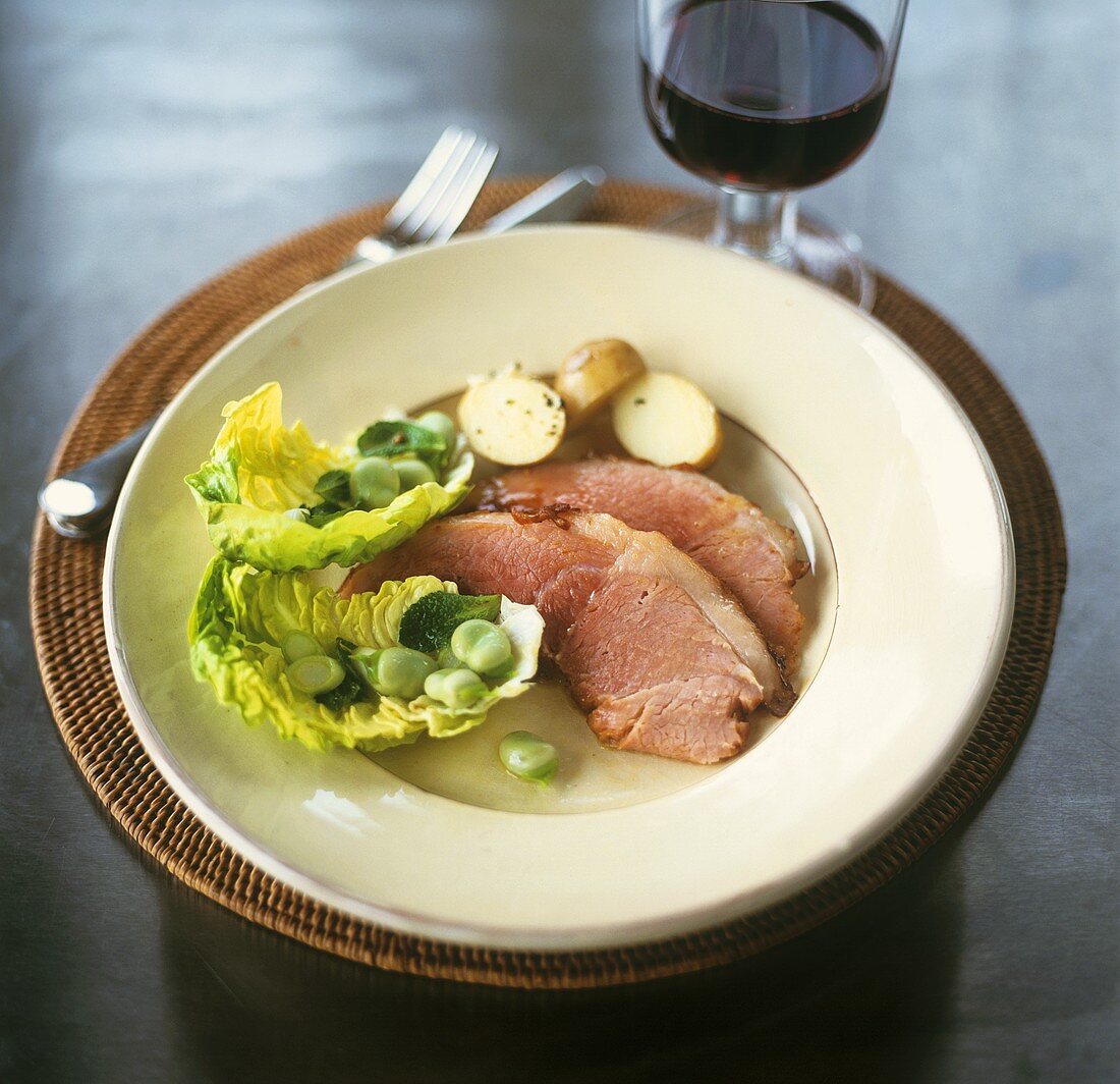Smoked pork loin with potatoes, lettuce and broad beand