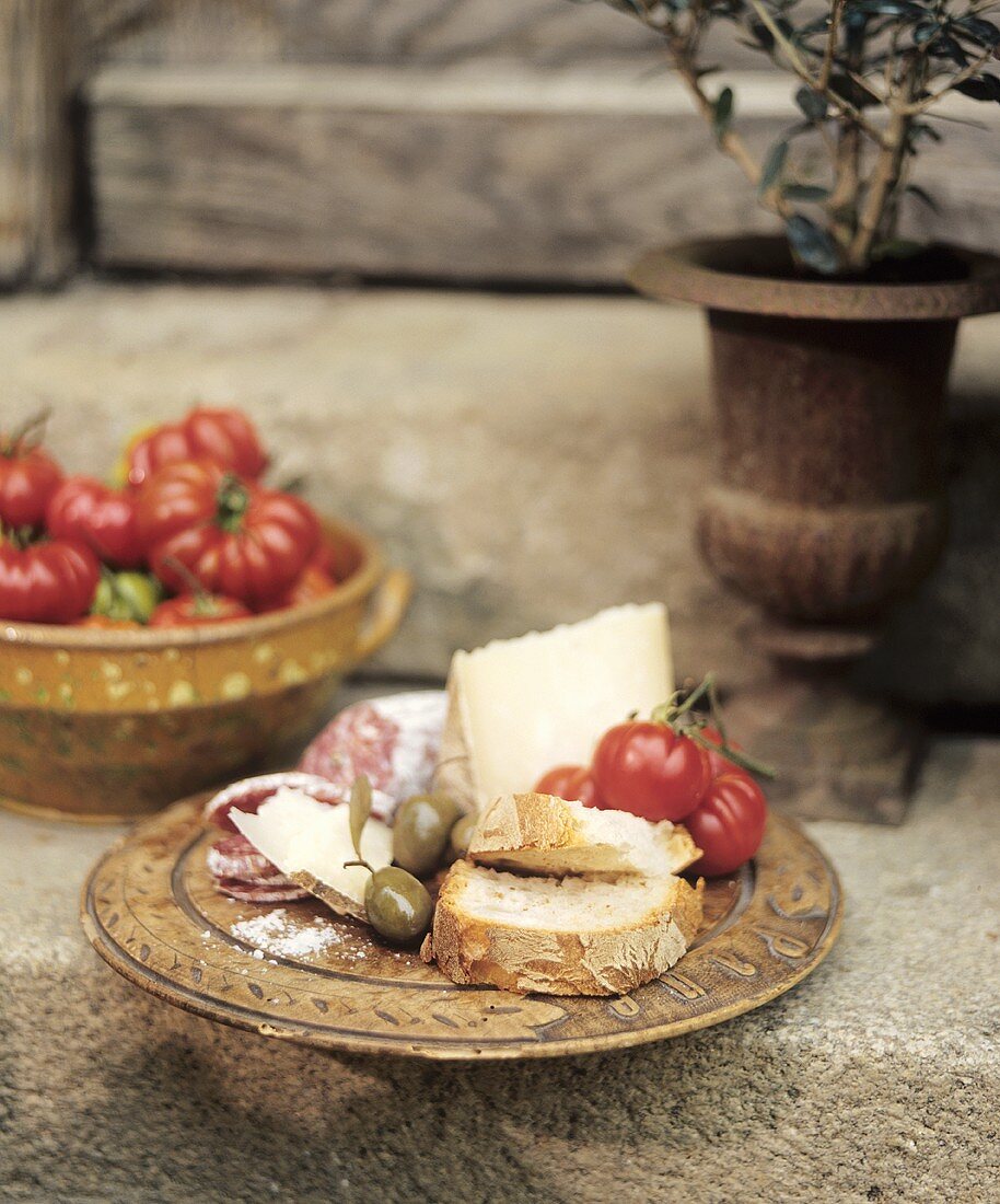 Italienische Brotzeit mit Käse, Hartwurst, Oliven und Tomaten