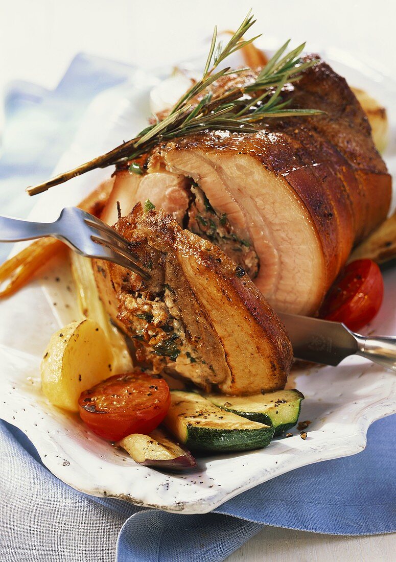 Rolled pork roast with ham stuffing and vegetables