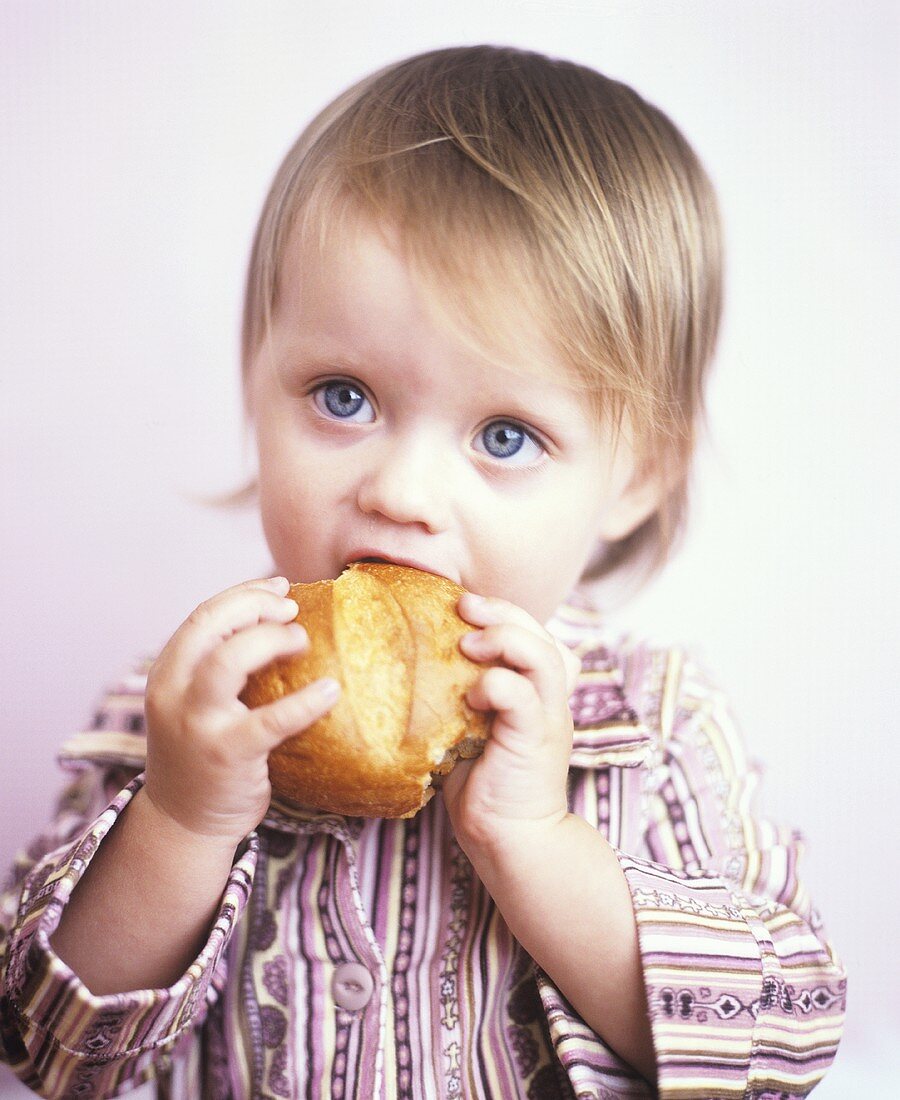 Kleines Mädchen isst Brötchen