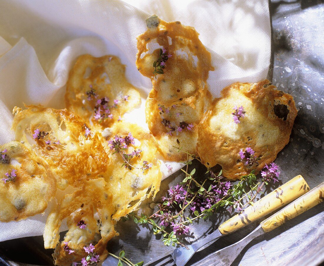 Home-made cheese crisps with thyme flowers