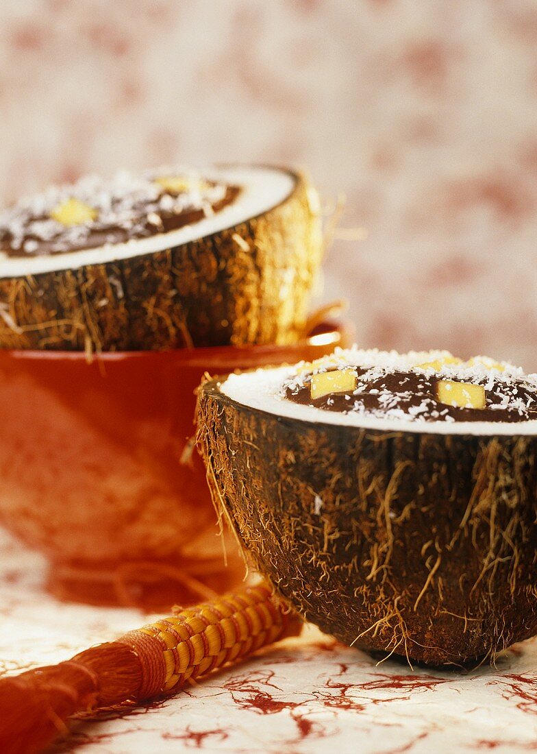 Chocolate cream with coconut & mango in hollowed-out coconut