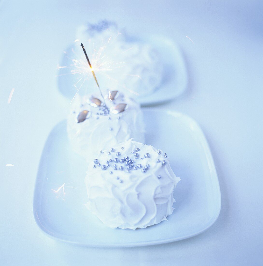 Small cakes with white icing and sparkler
