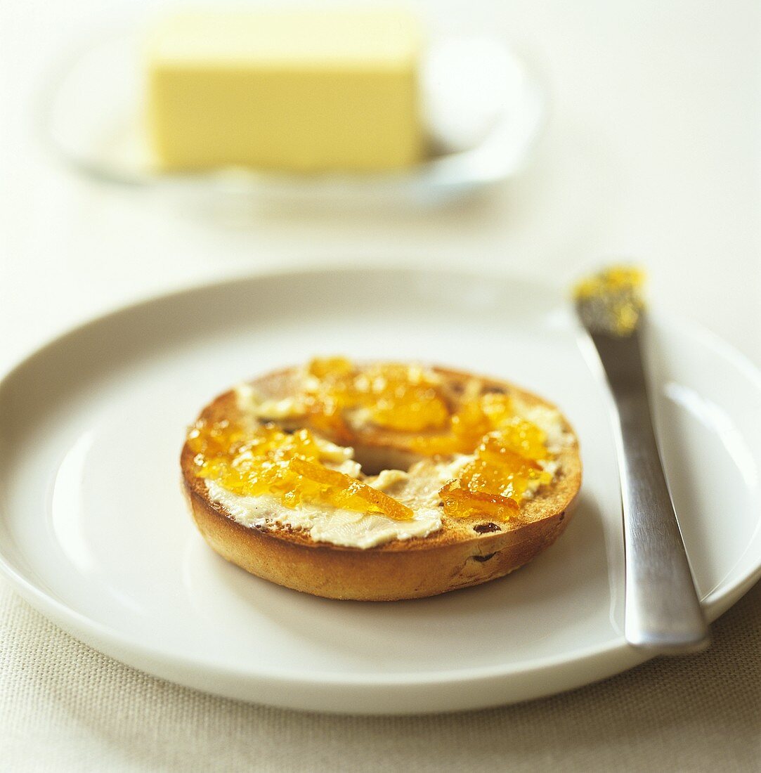 Toasted bagel with butter and marmalade