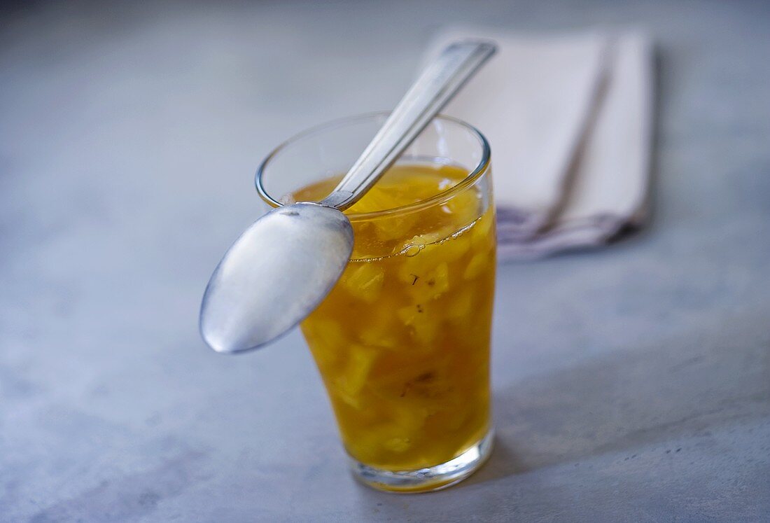 Pineapple jam in a glass with spoon