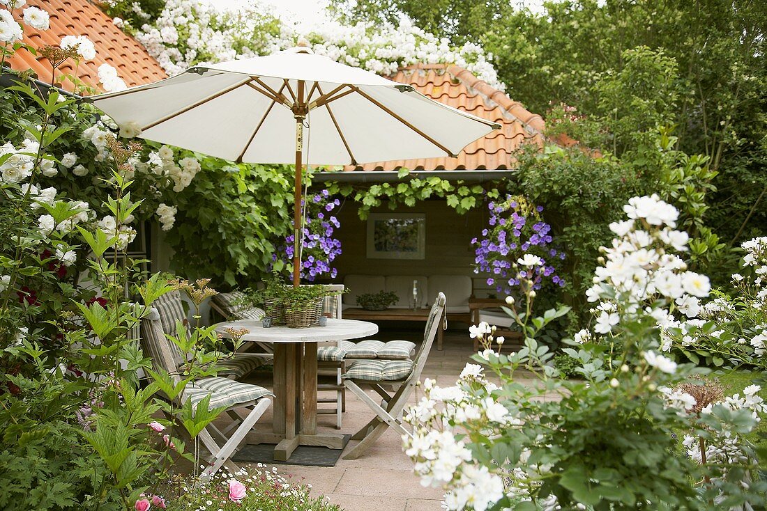 Sitting area with sunshade in summery garden