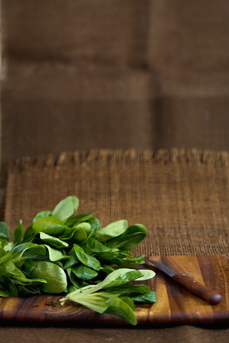 Corn salad with knife on wooden board