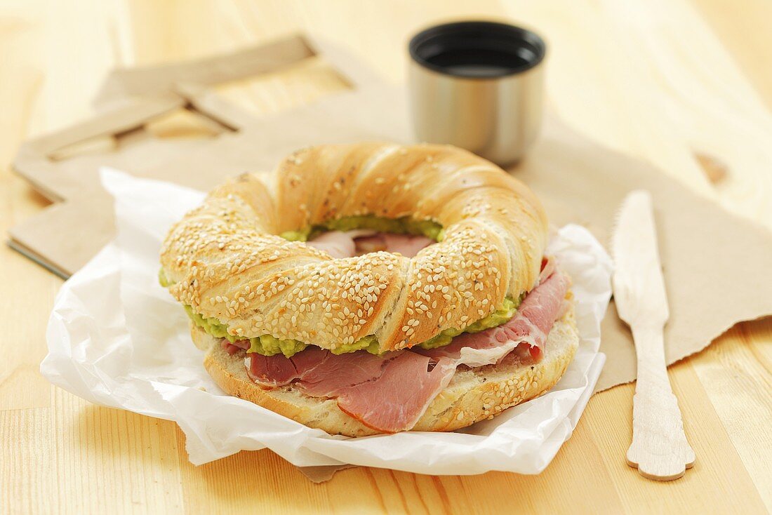 Bagel filled with ham and avocado paste