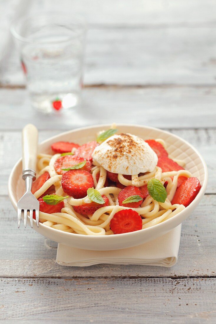 Pasta with strawberries, soft cheese and mint leaves