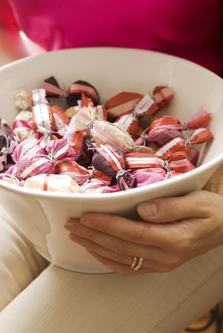 Woman holding bowl of sweets