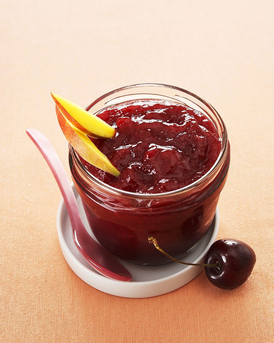 Cherry and mango jam in screw-top jar