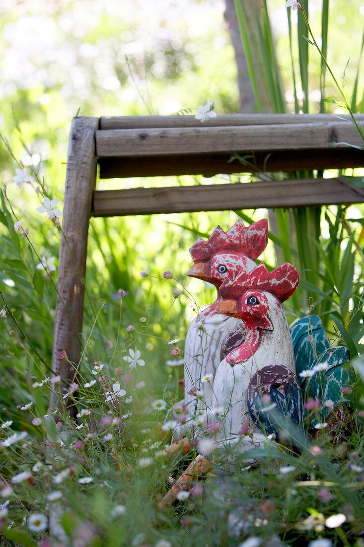 Hühnerfiguren auf Gartenbank