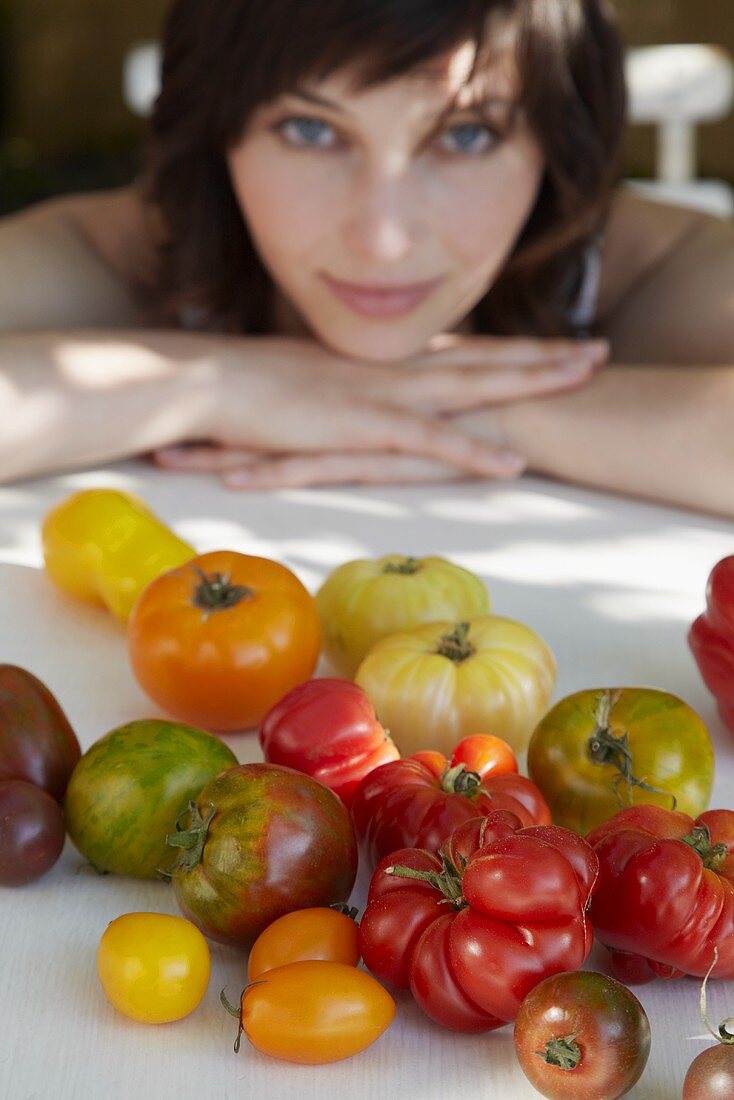 Various kinds of tomatoes, young woman in background