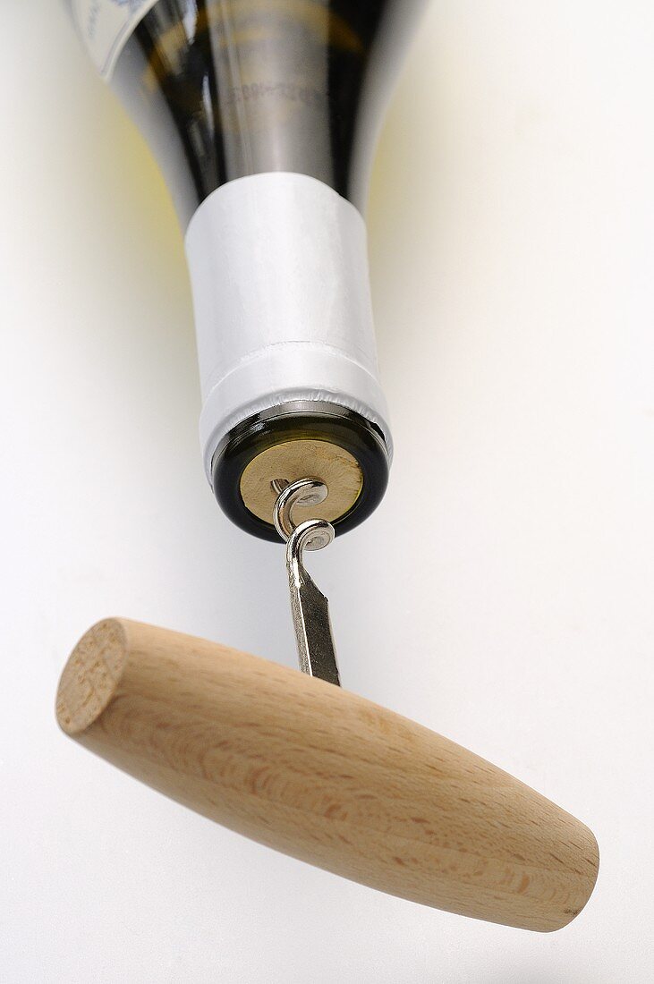 Bottle of white wine with corkscrew