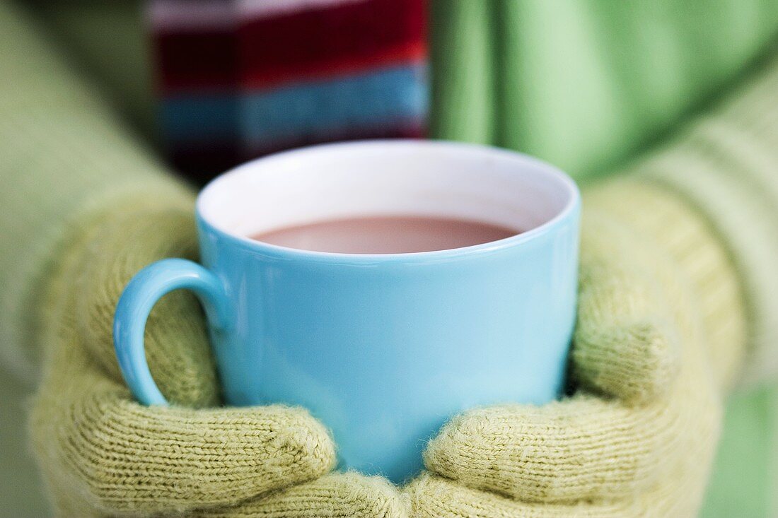 Hände halten eine Tasse heiße Schokolade