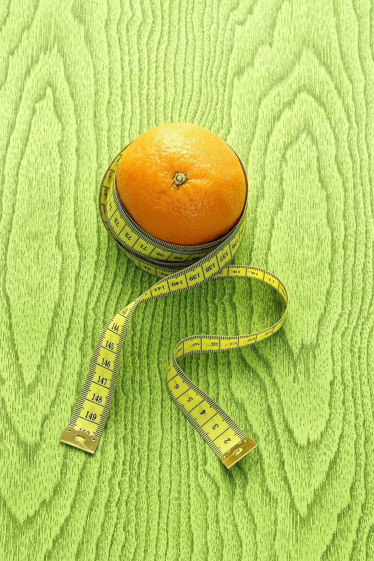 An orange with a tape measure