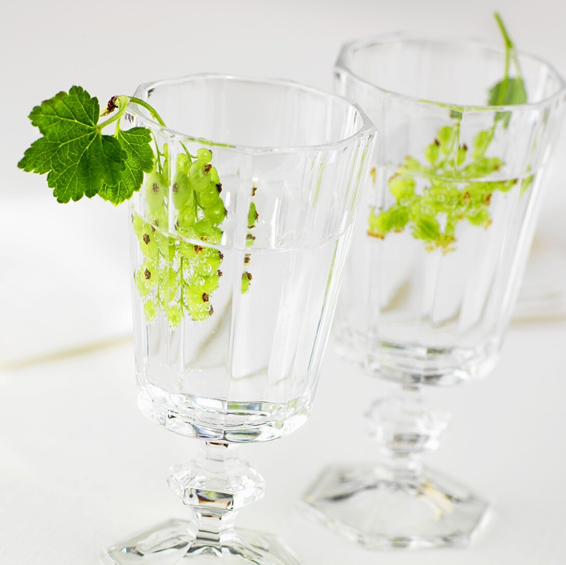Two glasses of water with green currants