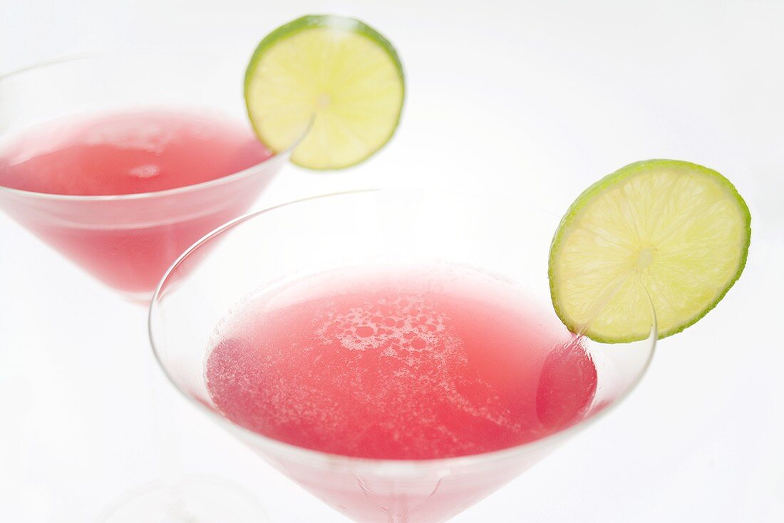 Two Cosmopolitan cocktails with slices of lime (detail)