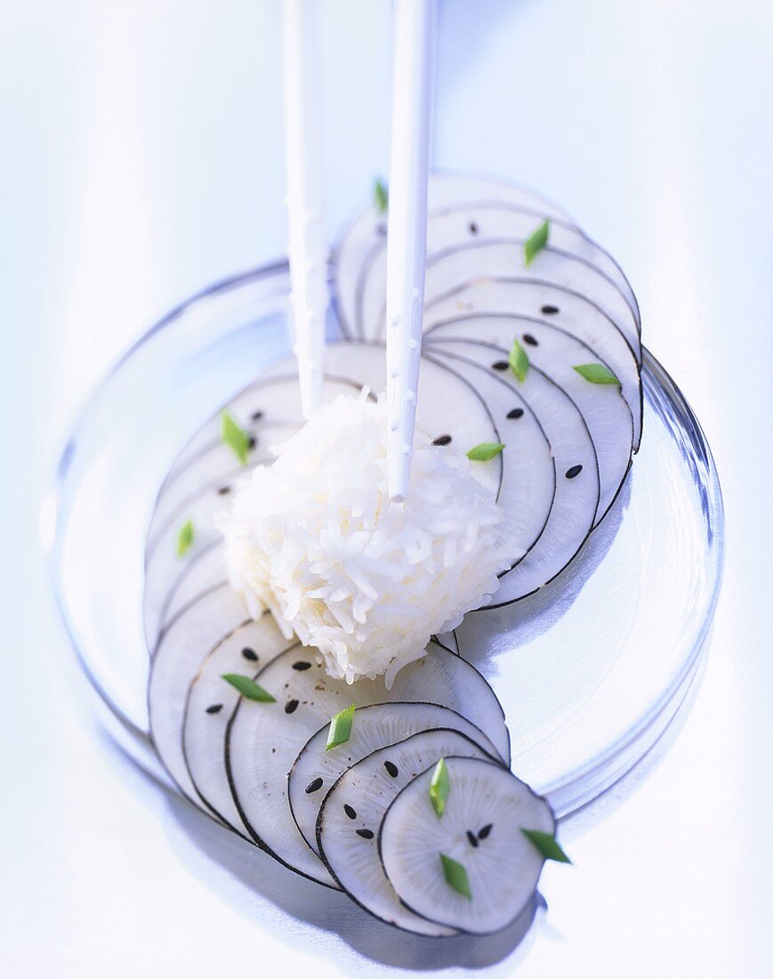 Reiswürfel mit Stäbchen auf Rettichscheiben