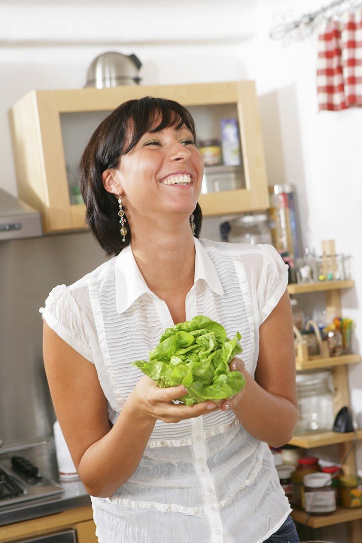 Young woman holding a lettuce in her hands