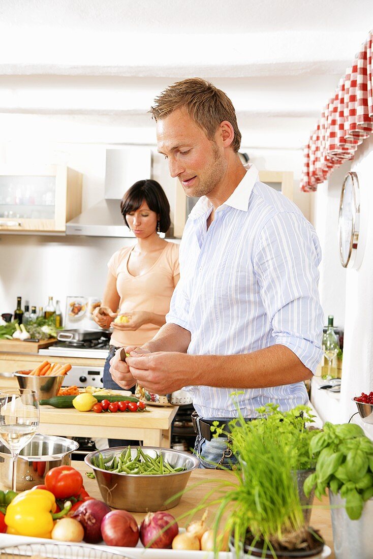 Young couple preparing vegetables in kitchen