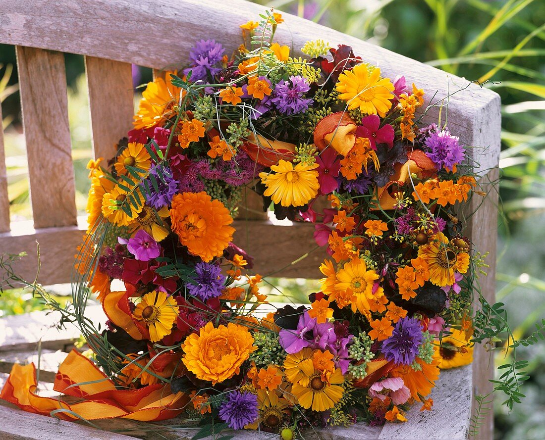 Autumnal wreath of helenium, phlox etc. on bench