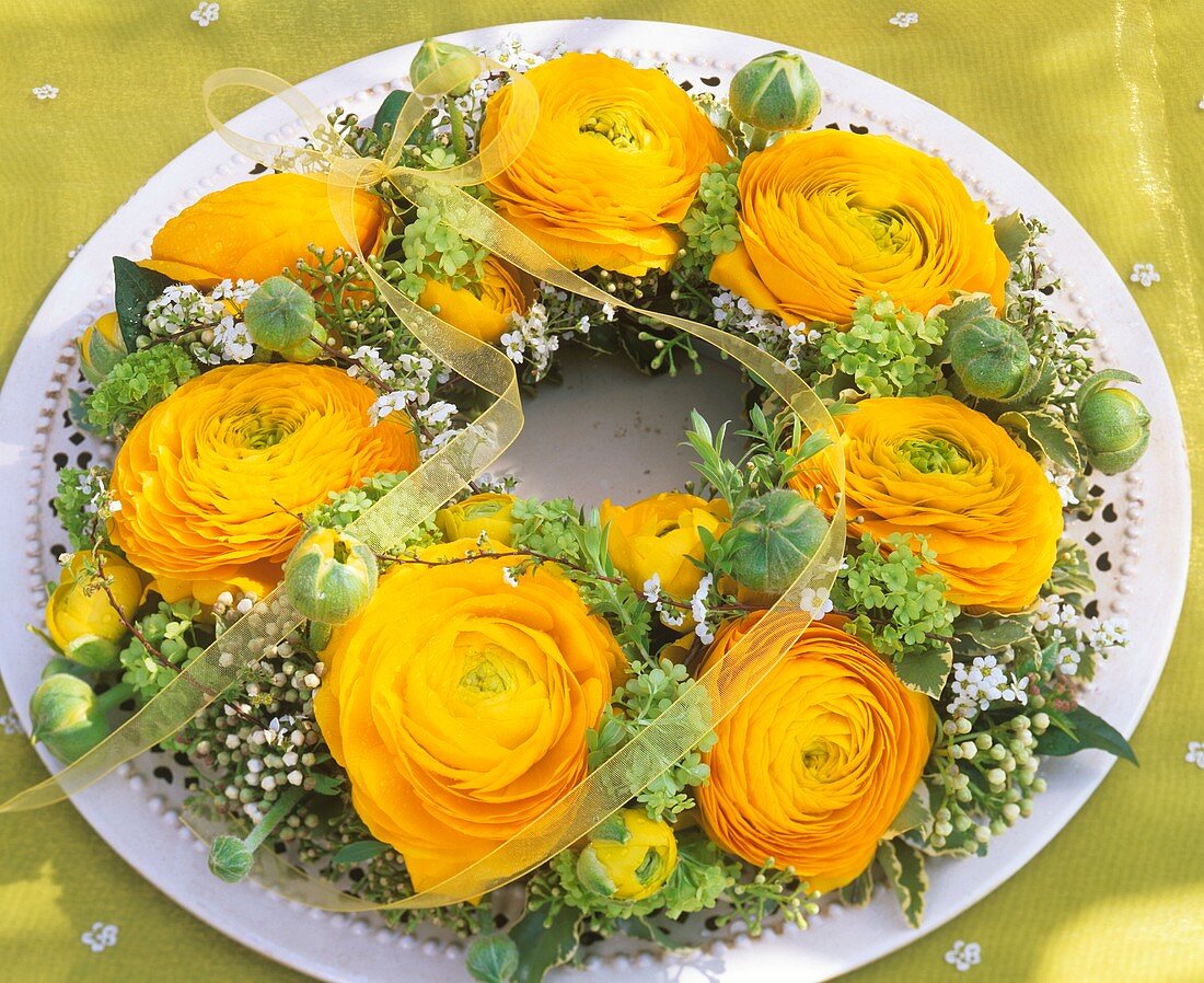 Wreath of yellow ranunculus, viburnum and spiraea