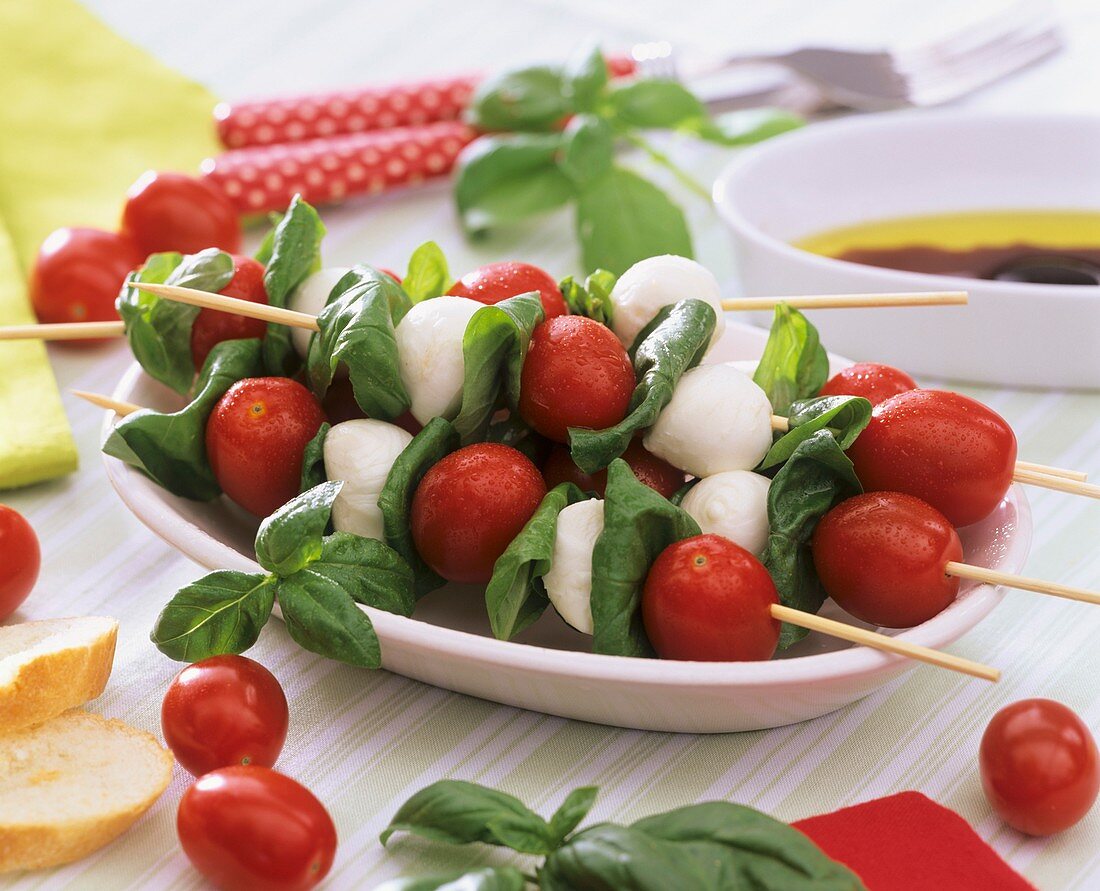 Tomatoes, mozzarella balls and basil on skewers