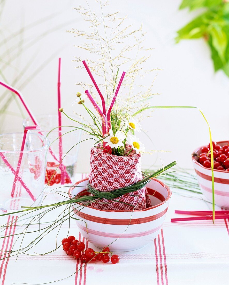 Napkin decoration of bent grass, marguerites & redcurrants