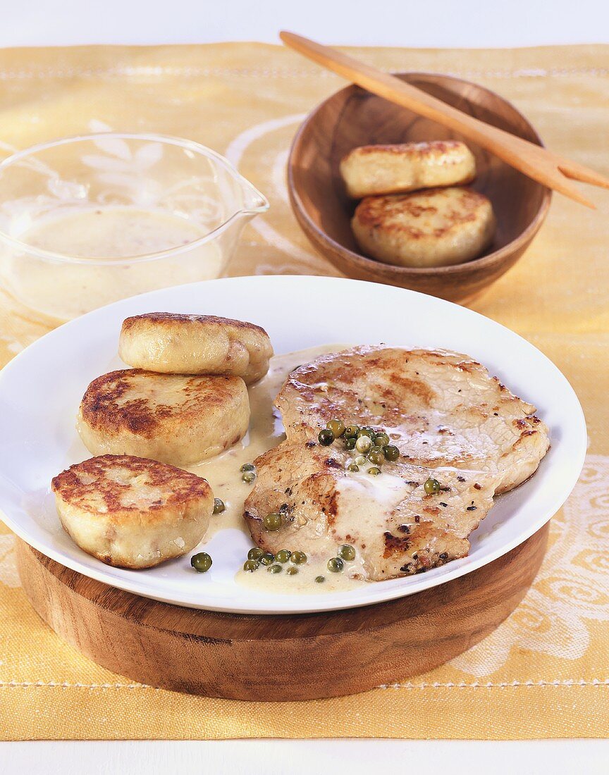 Escalopes in pepper cream sauce with potato cakes