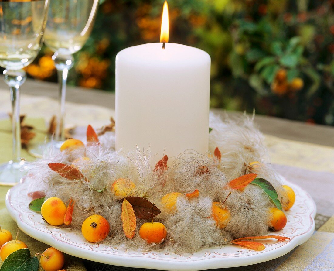 Wreath of clematis seedheads with crab apples & white candle
