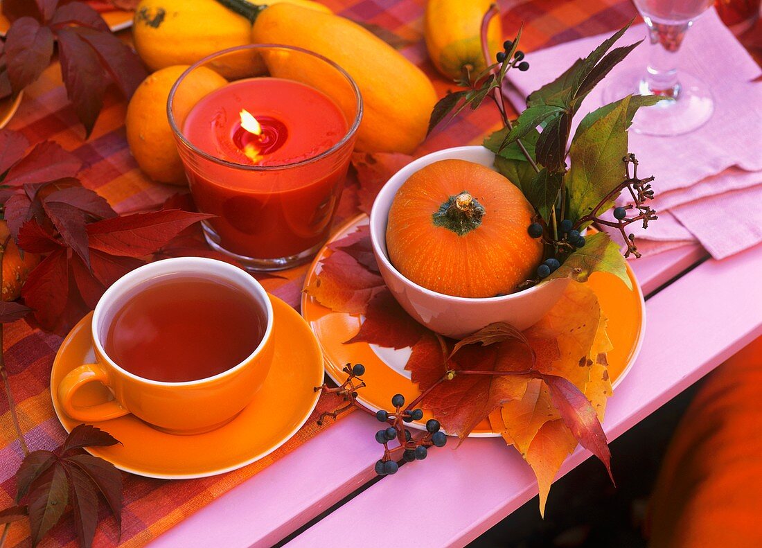 A cup of tea on a table with autumn decorations