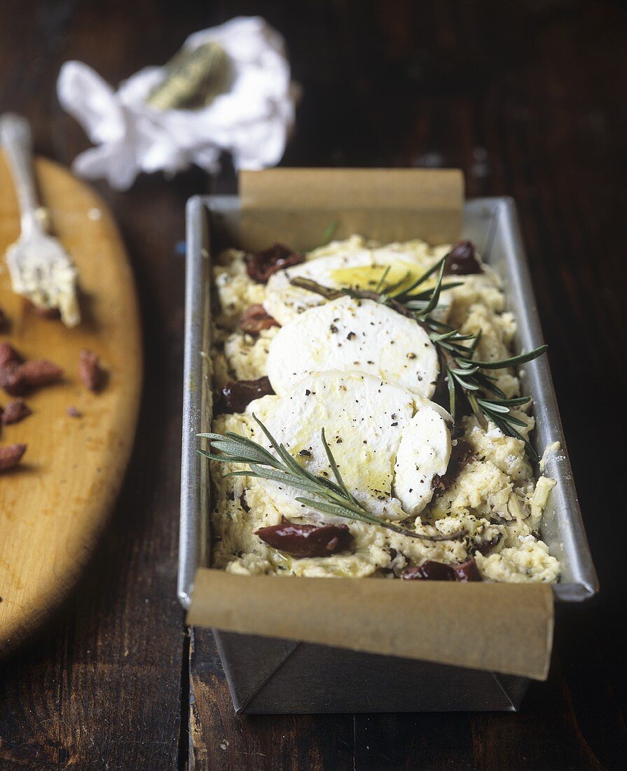 Unbaked goat's cheese and olive bread in loaf tin