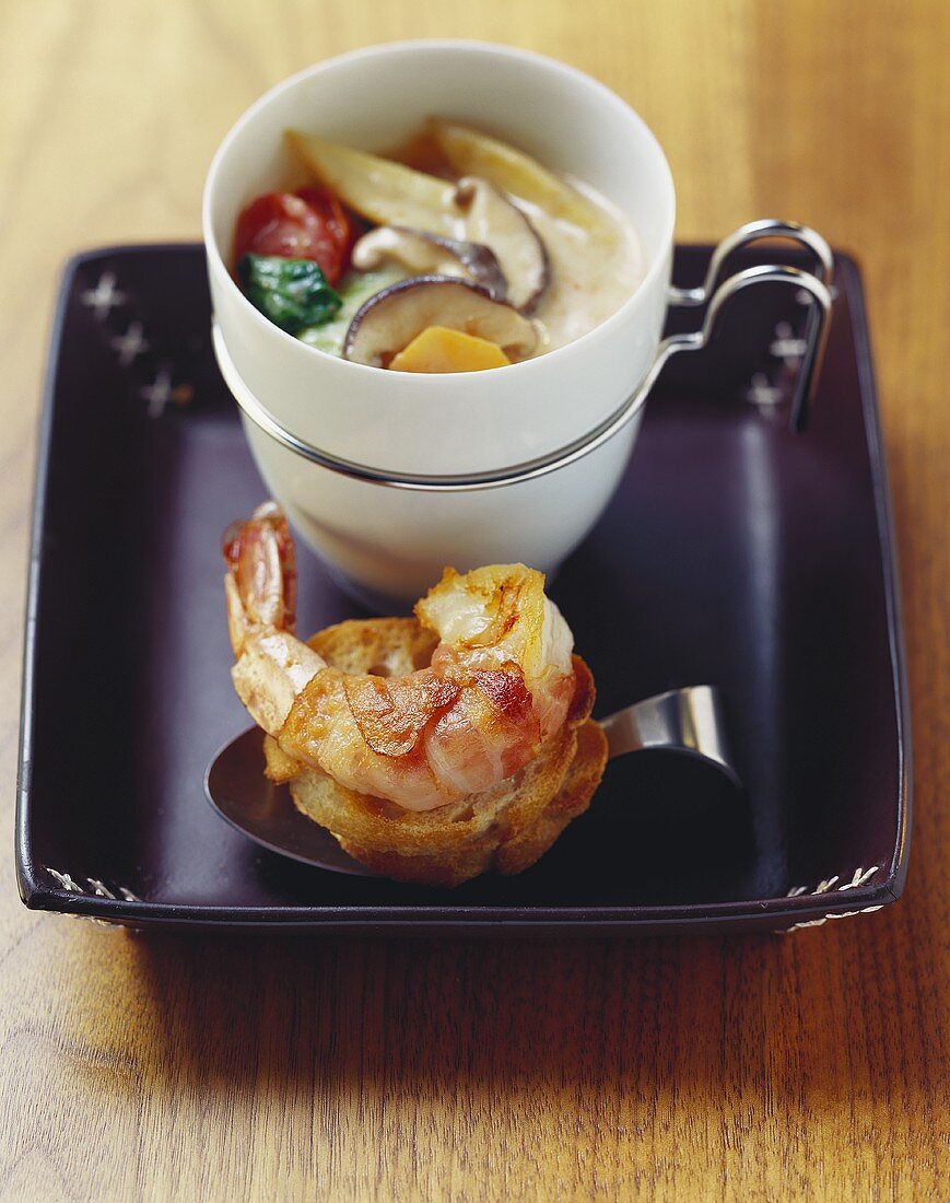 Asian coconut cream soup with bacon-wrapped prawn on toast