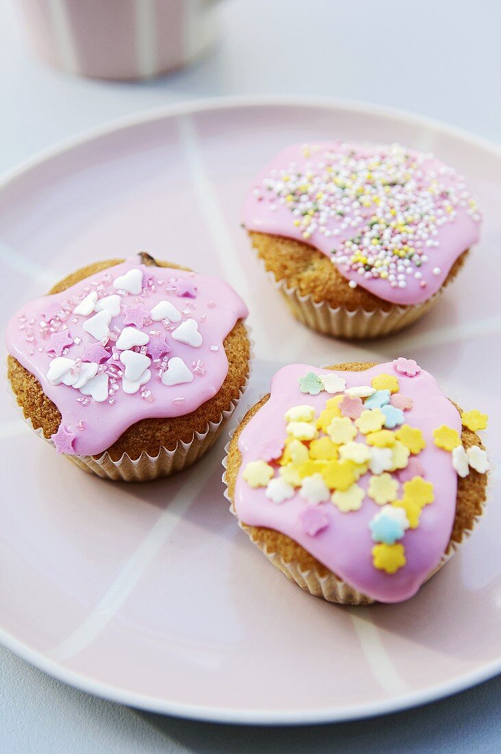 Drei Fairy Cakes mit rosa Zuckerguss und Verzierung
