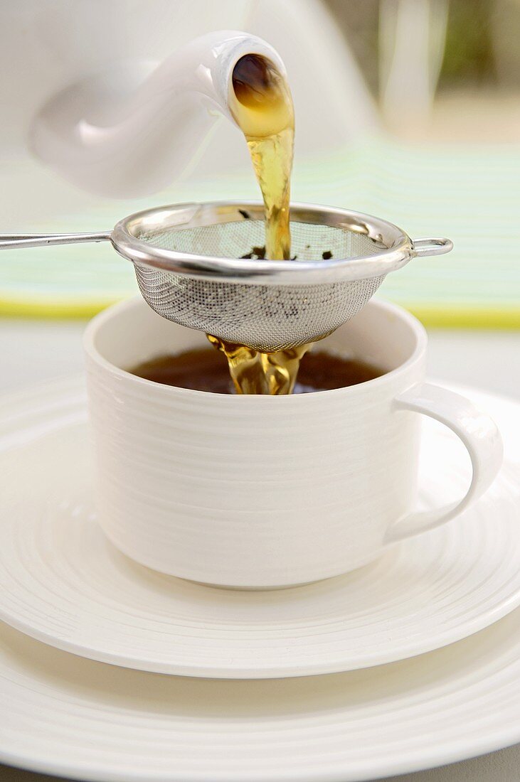 Pouring tea through a tea strainer