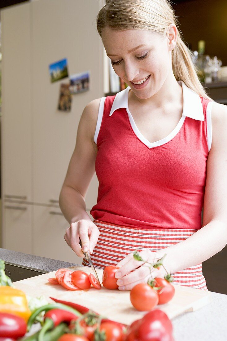 Young woman slicing tomatoes