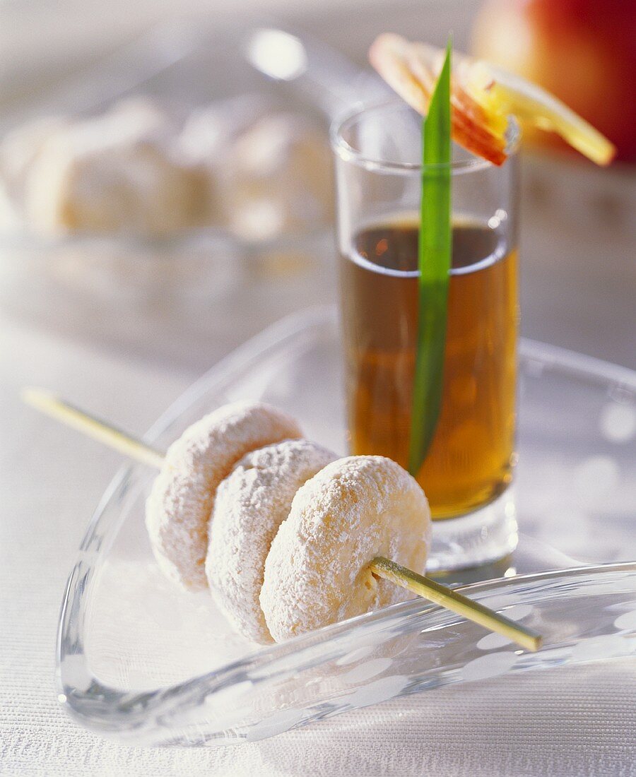 Marzipan cookies threaded on skewer, tea in background