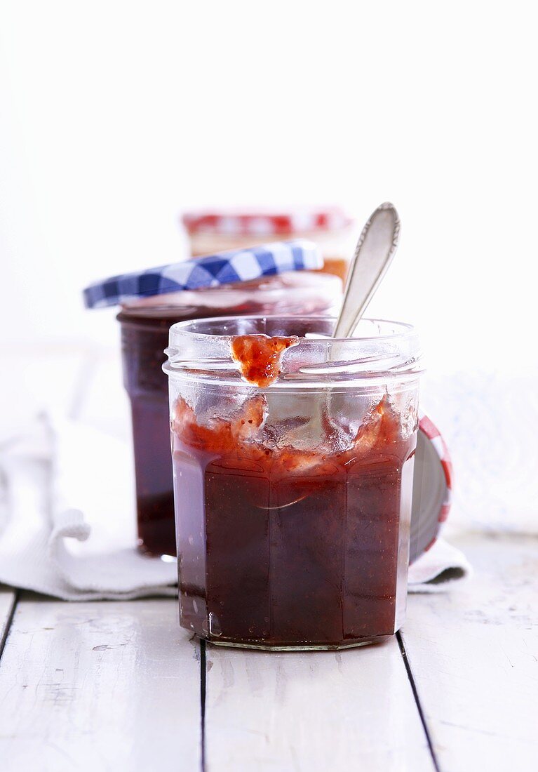 Selbstgemachte Erdbeermarmelade mit Löffel in geöffnetem Glas