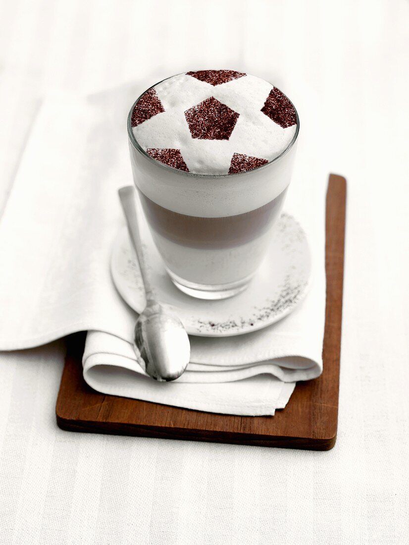 Latte macchiato with milk froth in football design